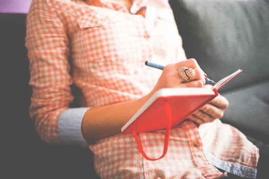Image of a lady making notes in a book